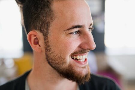 A portrait of young hipster man indoors, a close-up.