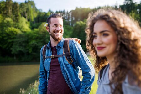 Young tourist couple travellers on a walk by lake in nature.の写真素材