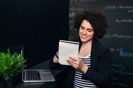 Young businesswoman with laptop in office, working.