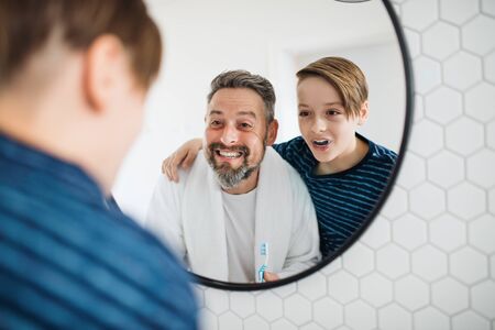 Mature father with small in the bathroom in the morning, grimacing.