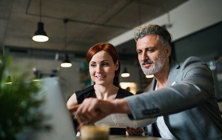 Man and woman having business meeting in a cafe, using laptop.の写真素材