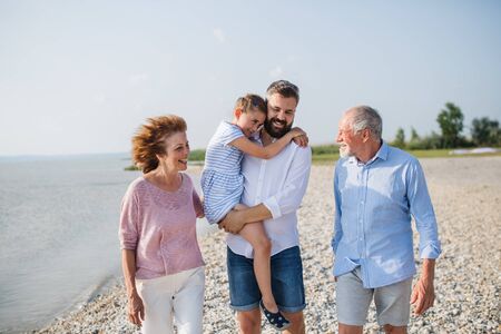 Multigeneration family on a holiday walking by the lake, talking.の写真素材