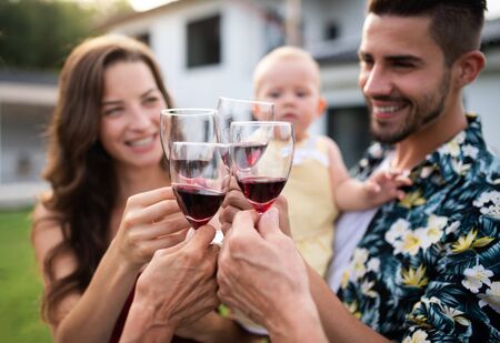Portrait of people with wine outdoors on family garden barbecue.の写真素材