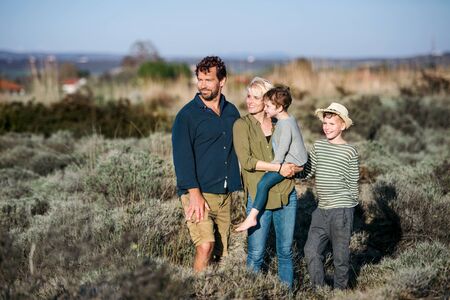 Young family with two small children standing outdoors in nature.の写真素材
