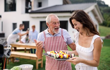 Portrait of multigeneration family outdoors on garden barbecue, grilling.の写真素材