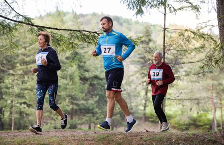 Group of multi generation people running a race competition in nature.