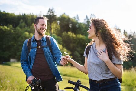 Young tourist couple travellers with electric scooters in nature.の写真素材