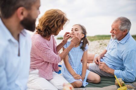 Multigeneration family on a holiday by the lake, having picnic.の写真素材