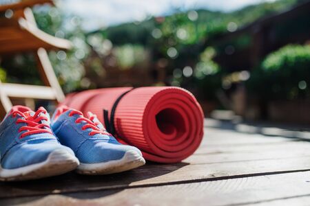 Exercise mat and trainers outdoors on a terrace in summer.の写真素材