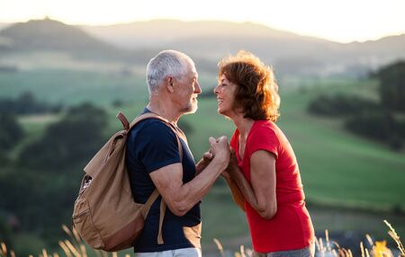 Senior tourist couple hikers with backpack standing in nature, resting.の写真素材