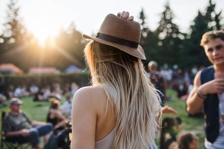 A rear view of young woman standing at summer festival or camping holiday.の写真素材