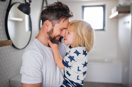 Mature father with small son indoors in bathroom, having fun.の写真素材