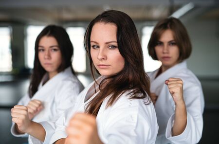 Group of young women practising karate indoors in gym.の写真素材