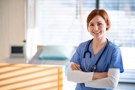 Portrait of female doctor or nurse standing in hospital room.の写真素材