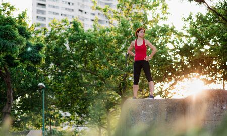 Young woman standing outdoors in city, resting after exercise.の写真素材