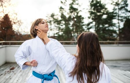 Young women practising karate outdoors on terrace.の写真素材