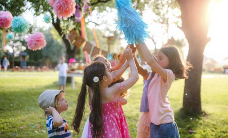 Small children with kite outdoors in garden in summer, playing.の写真素材