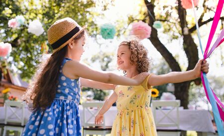 Small children outdoors in garden in summer, playing.の写真素材