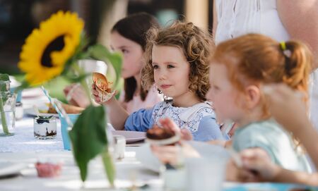 Small children eating on summer garden party, birthday celebration concept.の写真素材