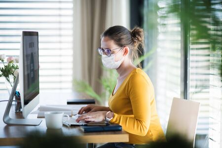 Woman working indoors at home office, Corona virus and quarantine concept.の写真素材