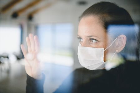 Woman with face masks indoors at home, Corona virus and quarantine concept.