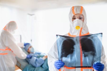 Medical team looking after infected patient in hospital, coronavirus concept.