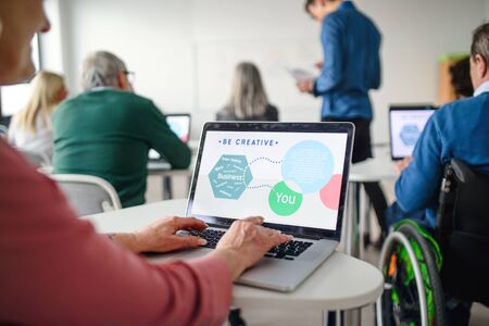 Rear view of senior people attending computer and technology education class.の写真素材