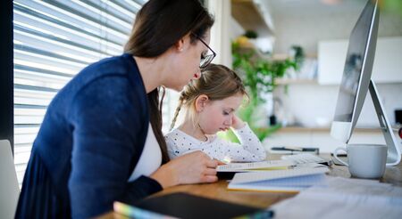 Mother and daughter learning indoors at home, Corona virus and quarantine concept.の写真素材