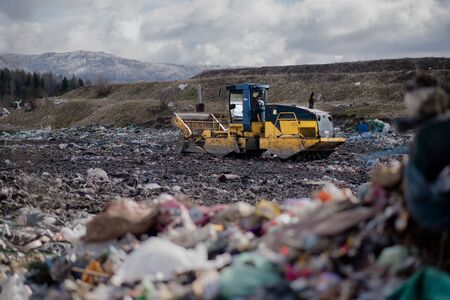 Garbage truck unloading waste on landfill, environmental concept.の写真素材