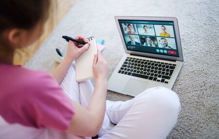 Unrecognizable young woman with laptop, online business call concept.