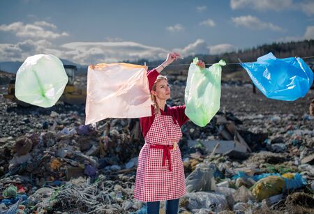 Woman on landfill, consumerism versus plastic pollution concept.の写真素材