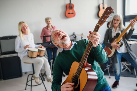 Group of senior people playing musical instruments indoors in band.の写真素材