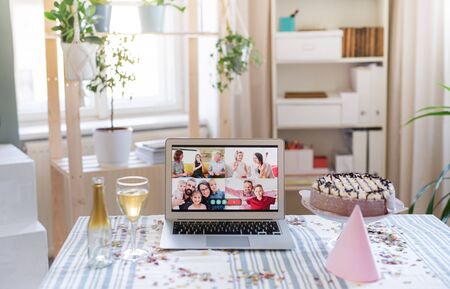Laptop on table indoors, family chat and distance birthday celebration.