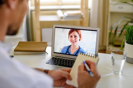 Unrecognizable man having video call with doctor at home, online consultation concept.