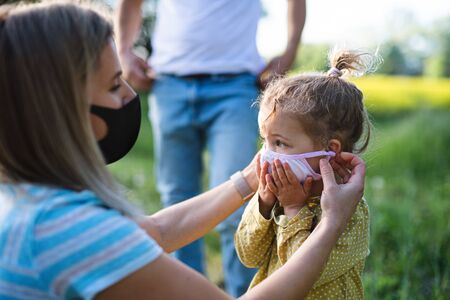 Family with small daughter on trip in nature, wearing face masks.の写真素材