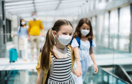 Family with two children going on holiday, wearing face masks at the airport.の写真素材
