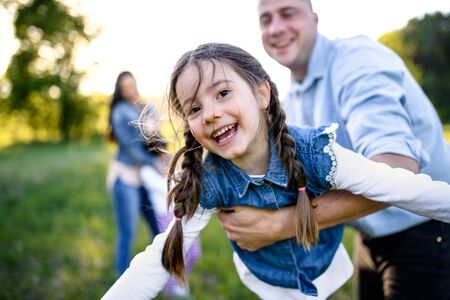 Father playing with small daughter outdoors in spring nature, having fun.の写真素材