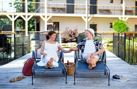 Senior couple realxing outdoors on holiday, holding hands.の写真素材