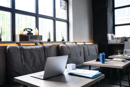 Laptops on desks in empty modern office.