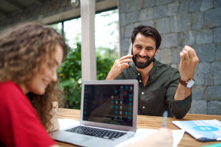 Young man and woman sitting indoors in office, business meeting concept.