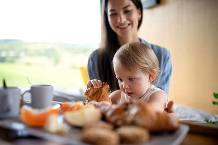 Young woman with small daughter indoors, weekend away in container house in countryside.の写真素材