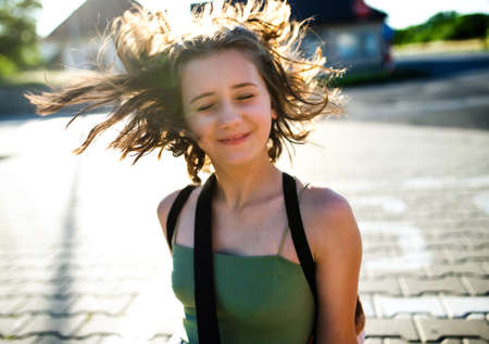 Portrait of teenager girl walking outdoors in city, having fun.