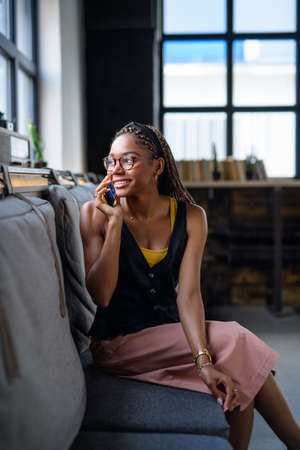 Portrait of young business woman indoors in office, using smartphone.