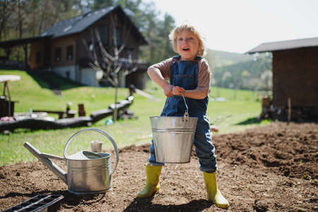 Small boy working outdoors in garden, sustainable lifestyle concept.の写真素材