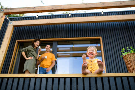 Low-angle view of family with small daughter outdoors, weekend away in container house in countryside.の写真素材