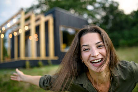 Young woman outdoors, weekend away in container house in countryside.の写真素材