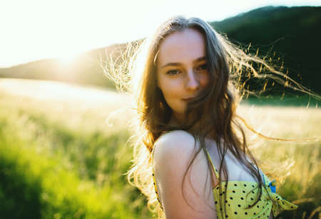 Portrait of young teenager girl outdoors in nature at sunset.の写真素材