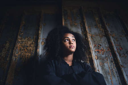 Portrait of mixed-race teenager girl standing indoors in abandoned building.の写真素材