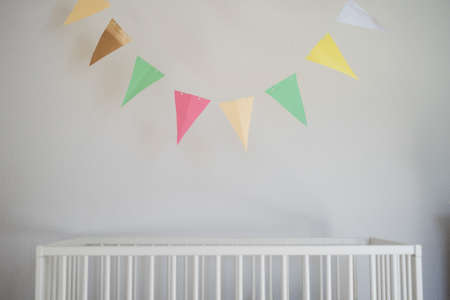 Cot in bedroom decorated for newborn baby.