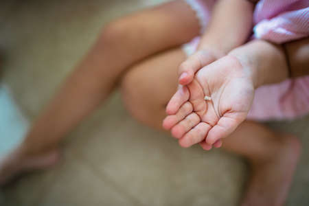 Unrecognizable small girl indoors, loosing baby tooth.の写真素材